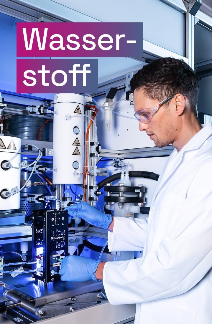 Wissenschaftler an einem AEM-Elektrolyse-Teststand, darüber der Text „Wasserstoff“.