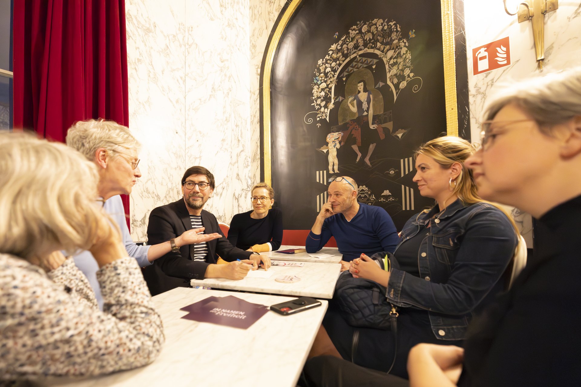 Besuchende der Veranstaltung diskutieren in Gesprächsrunden. 