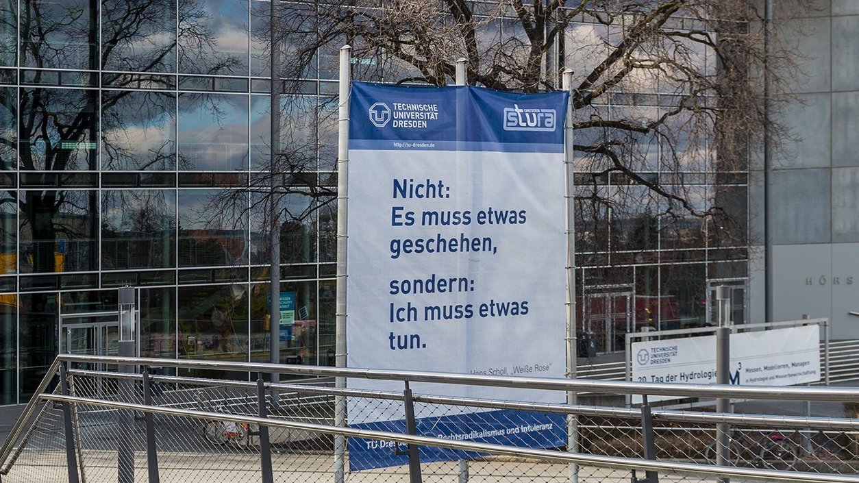 Banner vor der TU Dresden mit der Aufschrift "Nicht: Es muss etwas geschehen, sondern: Ich muss etwas tun".