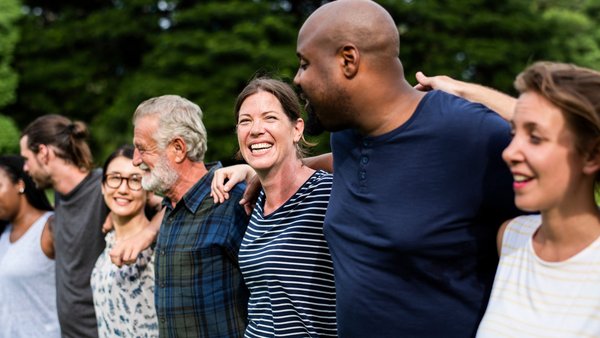WJ26_Personalisierte_Medizin_Vielfalt Eine vielfältige Gruppe Menschen steht Arm in Arm im Freien.